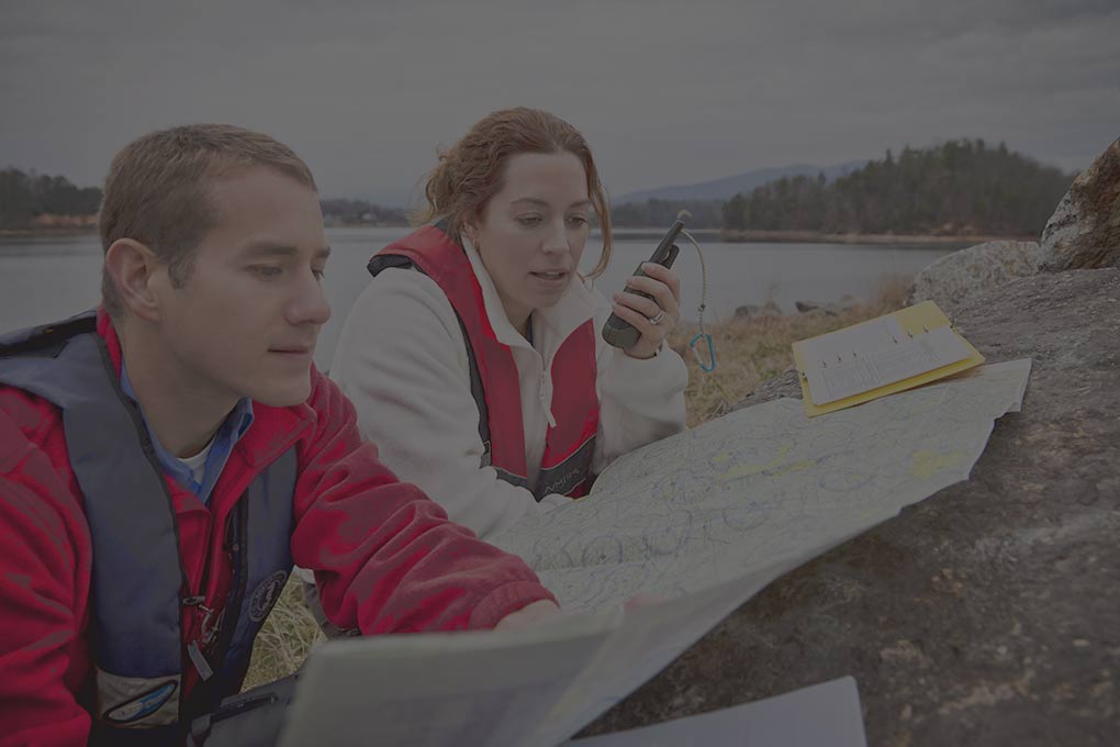 Researchers reviewing a map beside a lake